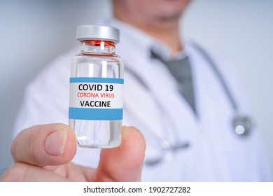 Male Doctor wearing PPE with a stethoscope on shoulder and holding syringe COVID-19 vaccine CORONA vaccine concept Healthcare and Medical  - Shutterstock ID 1902727282