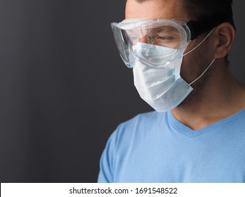 Male doctor wearing protective Mask and Goggles. Place for text. Dark background.