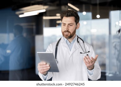 Male doctor in white coat conducting video call on digital tablet in modern office. Professional medical consultation, telemedicine, remote healthcare services concept. - Powered by Shutterstock