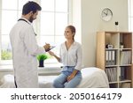 Male doctor in white medical uniform consult female patient in private hospital or clinic. Caring man therapist or GP write prescription do checkup for smiling woman client. Medicine concept.