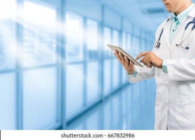 Male doctor working on computer tablet in the hospital or office background. Concept of medical data analysis and healthcare business. - Shutterstock ID 667832986