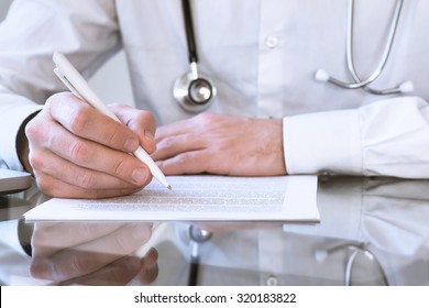 Male Doctor Writing Medical Prescription Or Certificate