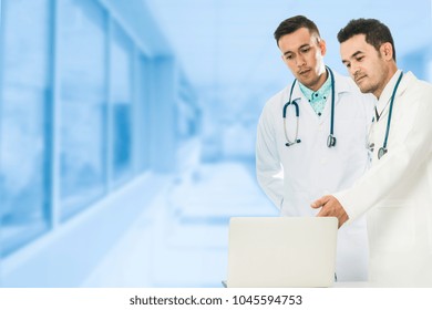 Male Doctors Discuss Data On Laptop Computer In Hospital, Doctors Office.