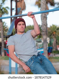 Male Doing Callisthenics On The Beach With An Determination Mood. One Arm Pull Up.