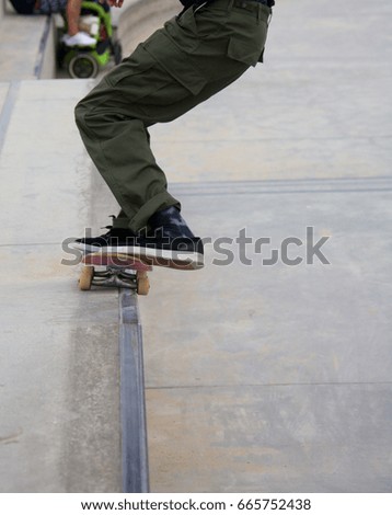 Similar – Image, Stock Photo Skateboarder performing a trick on a rail at a skatepark.