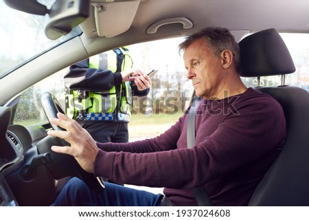 Male Driver Being Stopped By Female Traffic Police Officer With Digital Tablet For Driving Offence Imagine de stoc © 