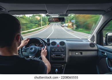 A male driver drives at speed through the streets of the city, a view from inside the car.