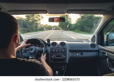 A male driver drives at speed through the streets of the city, a view from inside the car. - Shutterstock ID 2208065573