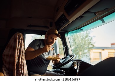 Male Driver Eating While Making Lunch Break In Truck's Cabin.