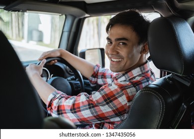 male driver looking at the back while driving his car