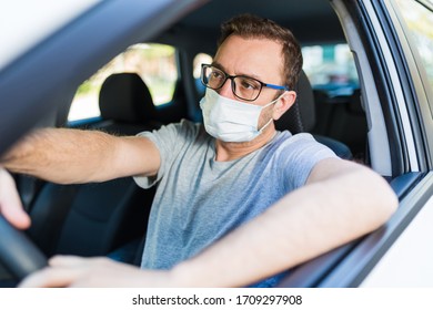 Male Driver With Protective Face Mask Inside Car.