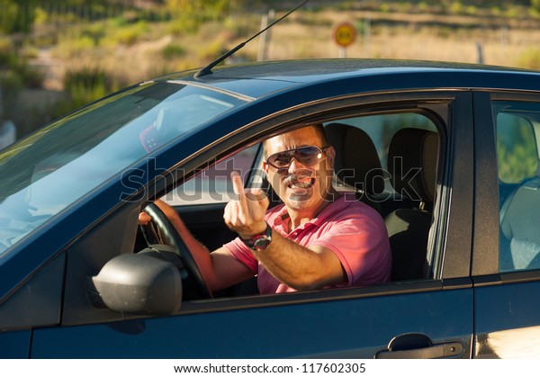 Male driver in a road rage\
attitude