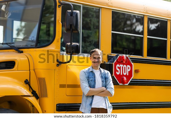 Male driver standing in\
front of bus