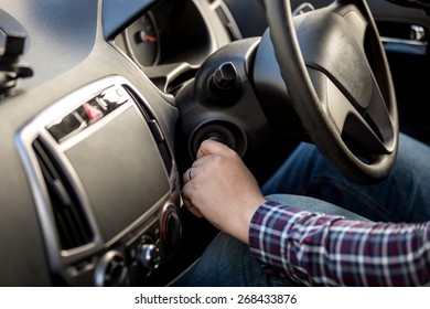 Male Driver Turning Ignition Key In Right-hand Drive Car