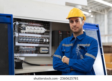 Male electrician engineer maintenance electric system in industry factory. Factory male worker at work in the industry factory, work with CNC machine. Factory engineer male worker maintaining machine - Powered by Shutterstock