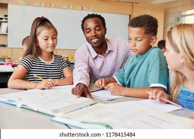 Male Elementary School Teacher Working In Class With Kids