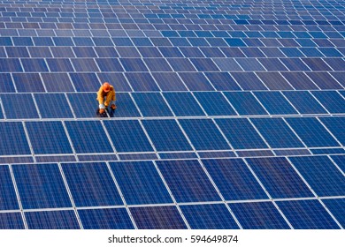 The male employee maintenance panels collect solar energy. - Shutterstock ID 594649874