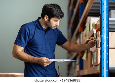 Male employee warehouse worker using clipboard checking products or parcel goods on shelf pallet in industry factory warehouse. Inspection quality control - Powered by Shutterstock