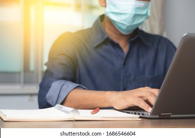 Male Employee Wearing A Health Mask Preventing Corona Virus Infection Covid-19, Concept Of Working From Home And Social Distancing Or Physical Distancing.