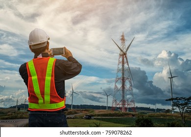 Male engineer checking and controlling with windmills for electric power production, Thailand.