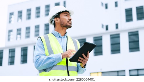 Male engineer checking data on digital tablet and inspecting construction site. Technician in a hardhat doing management and project planning outdoors. Skilled worker looking or overseeing operations - Powered by Shutterstock