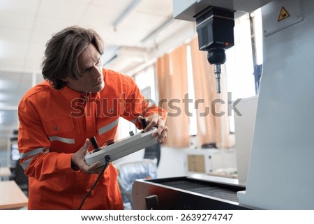 Male engineer or controller control CNC machine in workshop room