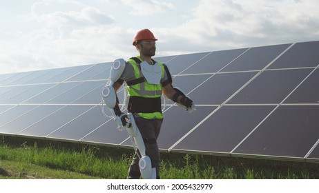 Male Engineer In Exoskeleton Walking On Solar Plant