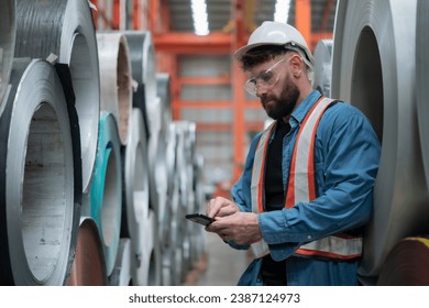 Male engineer or factory worker checking smartphone - Powered by Shutterstock