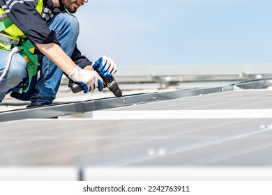 Male engineer installing or checking the working condition of solar panels on the roof or at the height of the factory for saving electricity was broken to use renewable energy from the sun - Shutterstock ID 2242763911