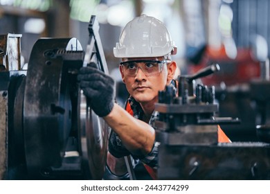 Male engineer metalworker industrial experienced operator technician worker in safety hard helmet working on lathe machine, professional man in industry technology manufacturing factory workshop - Powered by Shutterstock