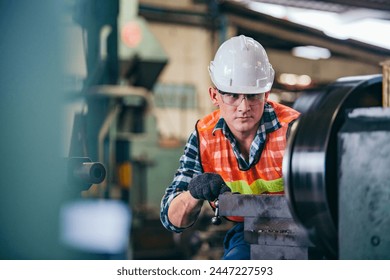 Male engineer metalworker industrial experienced operator technician worker in safety hard helmet working on lathe machine, professional man in industry technology manufacturing factory workshop - Powered by Shutterstock