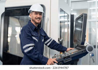 Male engineer operating cnc machine in control panel at factory. Smiling man technician in uniform and helmet safety working at workshop heavy metal industrial - Powered by Shutterstock