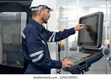 Male engineer operating cnc machine in control panel at factory. Smiling man technician in uniform and helmet safety working at workshop heavy metal industrial - Powered by Shutterstock