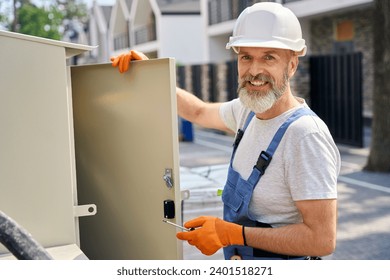 Male engineer posing for camera during electric switchboard installation