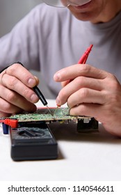 A male engineer is repairing an electronic board. Measurement of parameters and soldering of the electronic board. - Shutterstock ID 1140546611