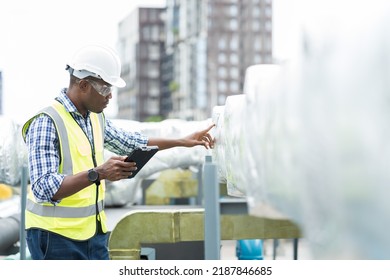 Male Engineer Or Male Technician Work With Digital Tablet At Construction Site Area. African American Male Engineer Worker Check Or Maintenance Pipe System For Ventilation And Air Conditioning