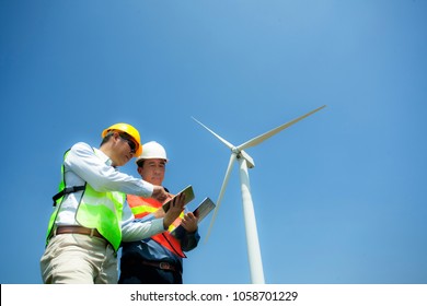 Male Engineer or technician at Work with tablet computer in wind turbine station,eletrician inspecting,analyse  electricity system of wind turbine generator. wind ,green, alternative energy concept. 