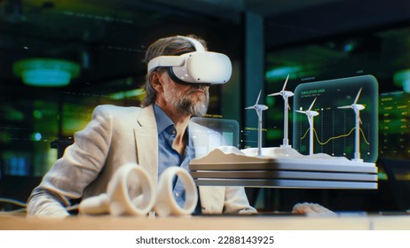 Male engineer uses VR headset, watches and checks engineering project with wind turbines in virtual reality. Talk via video call using vr app. 3D hologram. Future innovative digital AI technologies.