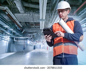 Male engineer. Utility pipes in background. Engineer stands next to ventilation pipes. Ventilation system design concept. Industrial ventilation system. Engineering communications plan development