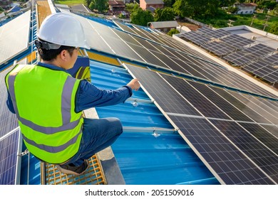 A Male Engineer Working On A Solar Power Plant Checks The Maintenance Of Solar Panels On The Roof.