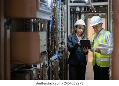 Male engineers oversee the intricate operations of the power plant, while female engineers contribute fresh perspectives and innovative solutions to enhance energy efficiency. - Powered by Shutterstock