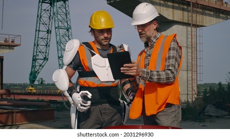 Male Engineers Using Tablet On Construction Site Together