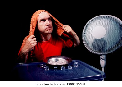 Male Enjoying Soft Breeze Of A Fan And Ice