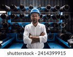 Male entrepreneur with arms crossed standing in steel mill