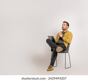 Male entrepreneur with laptop thinking business ideas and sitting on chair over white background - Powered by Shutterstock