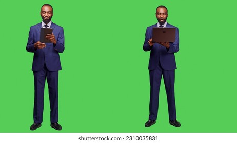 Male entrepreneur using videocall meeting in studio, holding laptop and tablet to talk to people on online videoconference call. Businessman attending remote internet teleconference. - Powered by Shutterstock