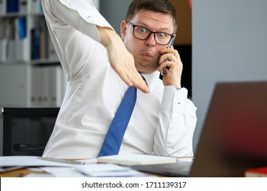 Male executive talking cellphone about bad consequences of world financial crisis for business concept. Businessman demonstrating financial market crash with hands articulation portrait - Shutterstock ID 1711139317
