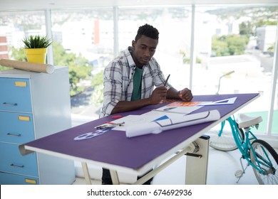 Male executive working over drafting table in office - Powered by Shutterstock