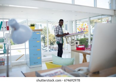 Male executive working over drafting table in office - Powered by Shutterstock