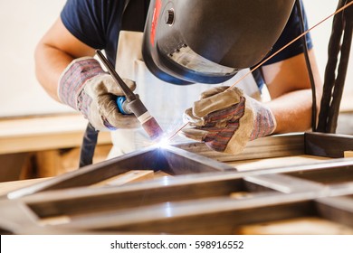 Male in face mask welds with argon-arc welding - Shutterstock ID 598916552